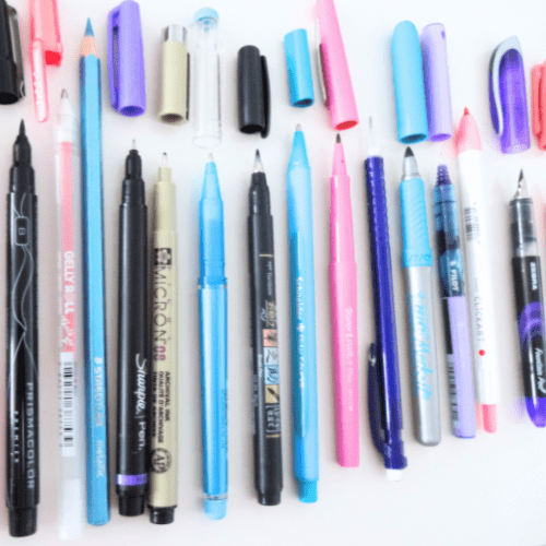 Colorful pens placed in a row with their caps off.