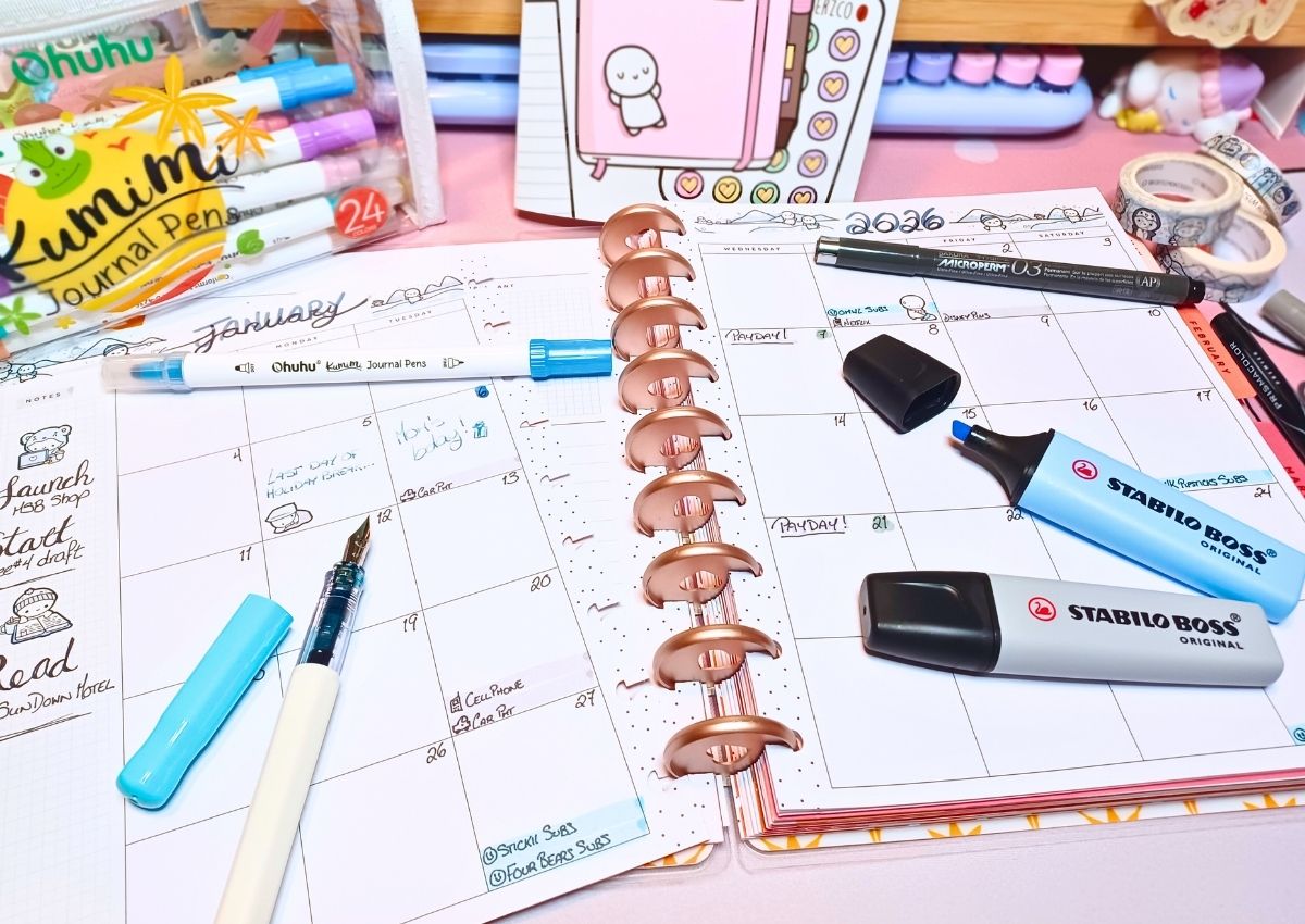 Filled-in two-page January monthly spread decorated with cute stickers and gray and blue accents