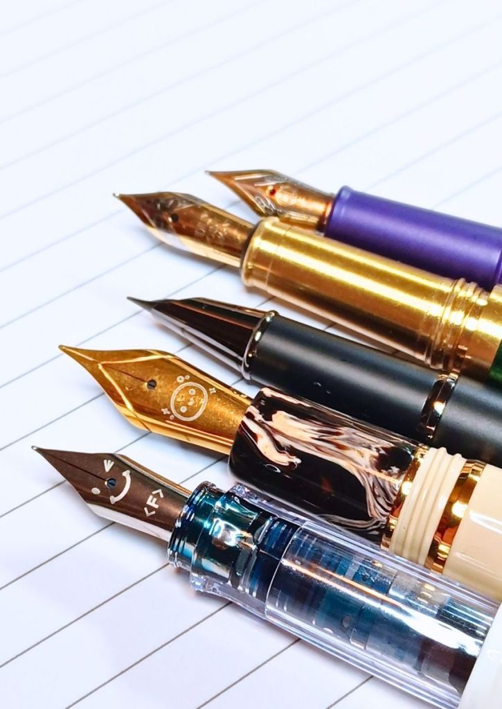 A range of fountain pen nibs of silver or gold color.