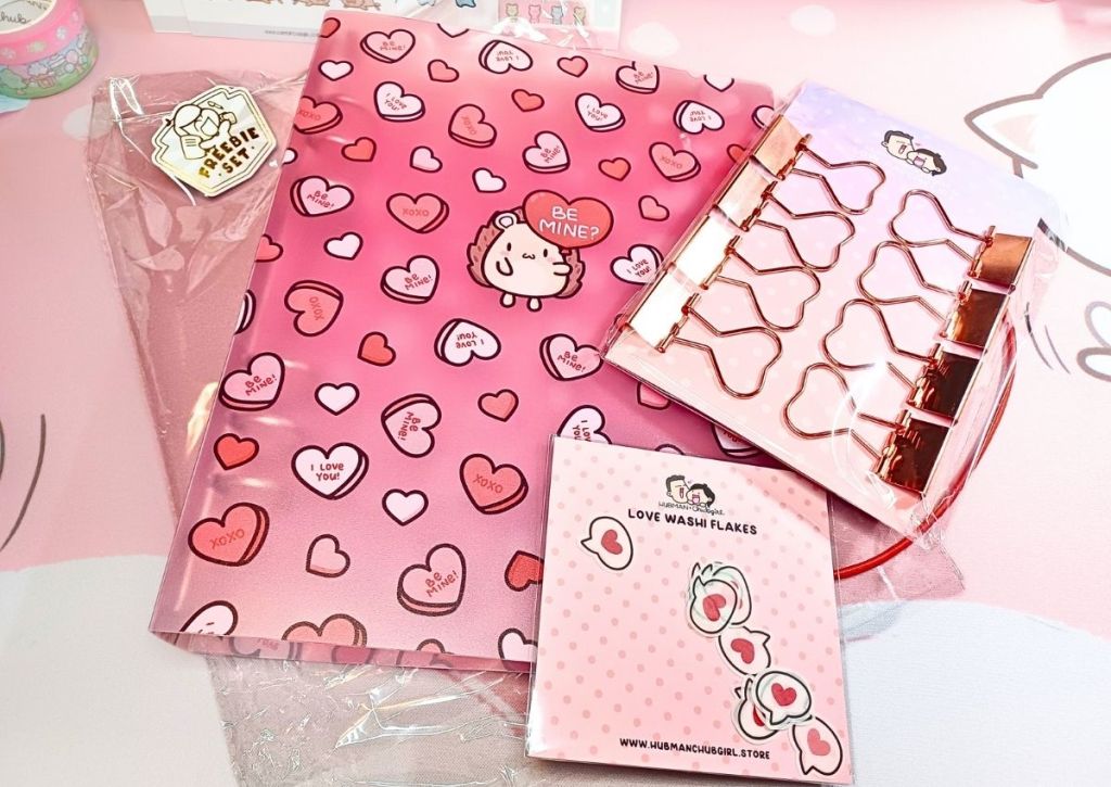 Three cute items (a binder, clips, and washi tape flakes) from a cute red and pink design inspired by love.