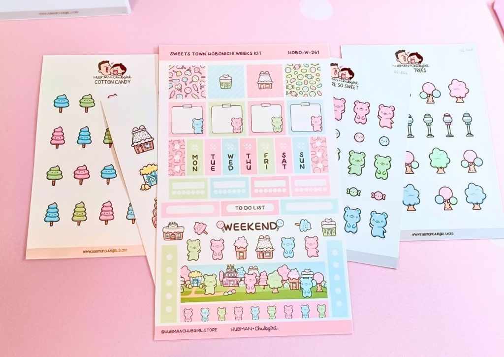 A stack of cute and colorful candy sticker sheets with a single prominent sheet featuring an array of functional and decorative stickers made for the Hobonichi Weeks planner.
