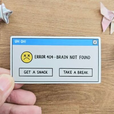 A hand drawn sticker made to resemble a computer error with the words "Error 404 - Brain not found" and two buttons at the bottom offering the options to "Get a snack" or "Take a break"