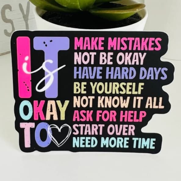 A vinyl die cut sticker with colorful words on a black background saying "It's okay to make mistakes, not be okay, have hard days..."