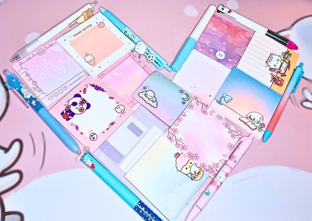 A pastel heart made of various pens and cute sticky notes.