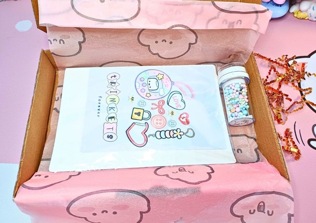 Pink tissue paper with a smiling clouds design, and cute and colorful stationery items.