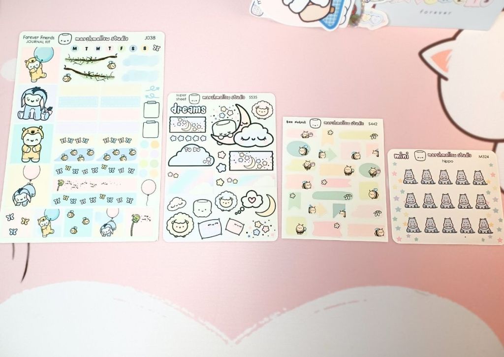 Four sticker sheets in a row showing the different between sizes ranging from mini sheets to jumbo sheets.