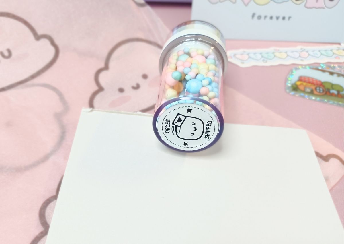 A small stamp with a cute design saying "Order shipped" on it.