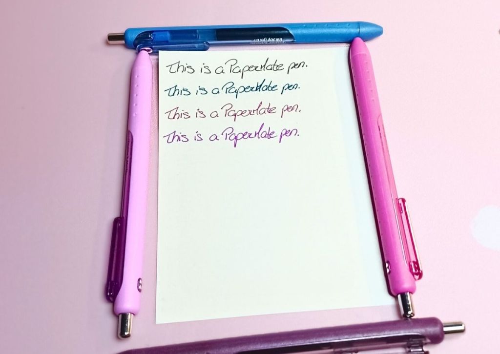 A page with a writing test repeated over and over, surrounded by the colorful PaperMate Candy Pop edition pens.