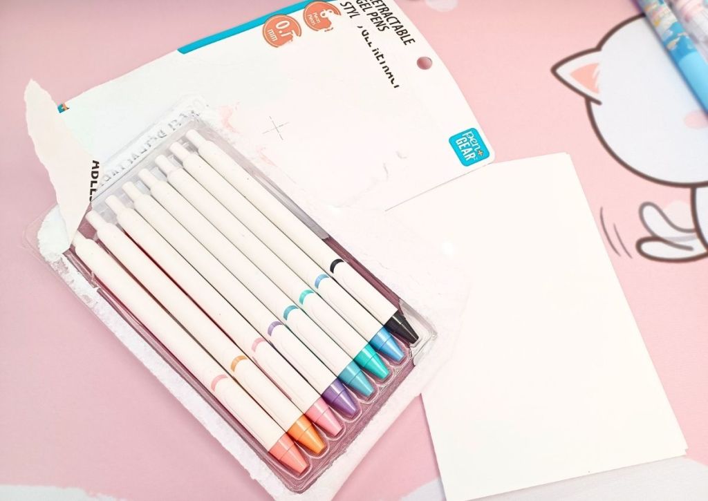 Eight pens resting in their packaging plastic tray, their back white and their tips eight different colors.