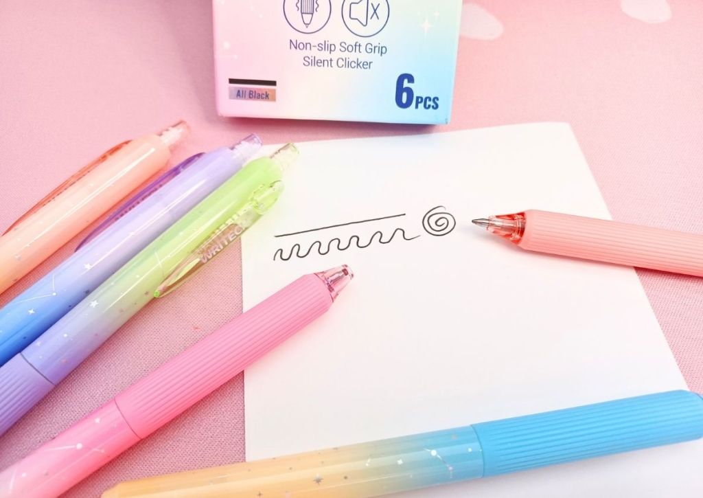 A white sheet with various pen tests on it, surrounded by the colorful Writech Nebula pens.