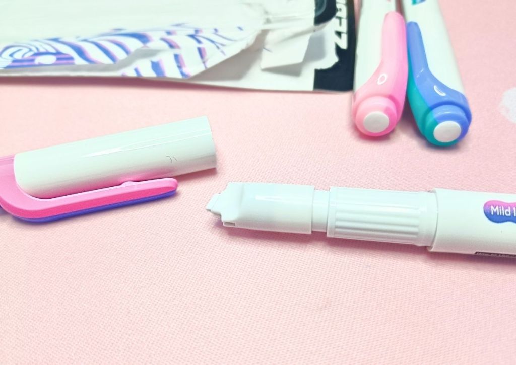A white pen with the cap pulled off to reveal an odd-looking white tip that looks like a second cap.