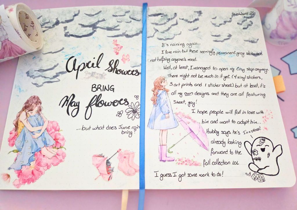 An opened journal with stickers of girls, umbrellas and pink flowers on a gray sky background.