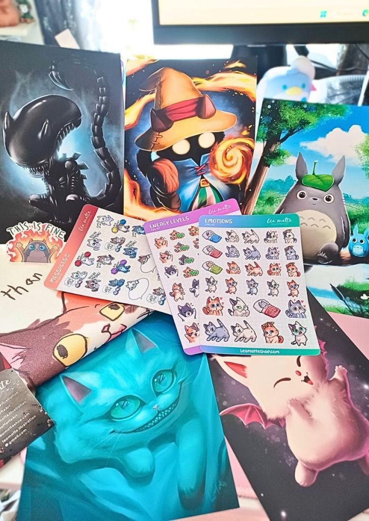 A variety of stunning art prints featuring well-known characters. Also, sticker sheets and a tote bag all featuring cats.