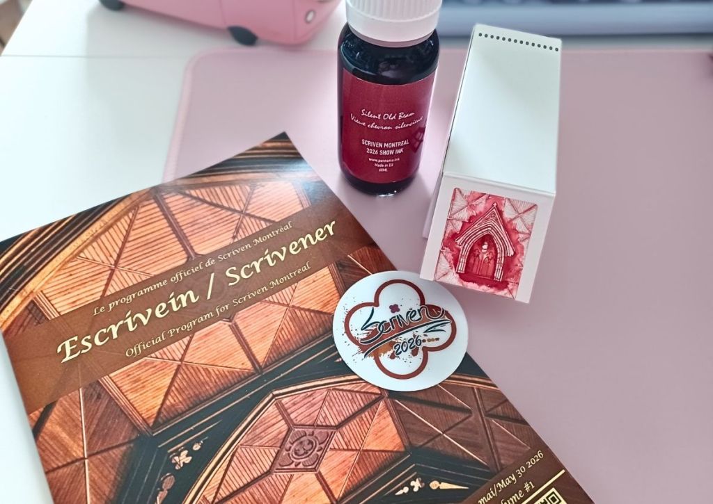 A pamphlet named "Scrivener", a sticker with the Scriven logo, and a bottle of burgundy ink,