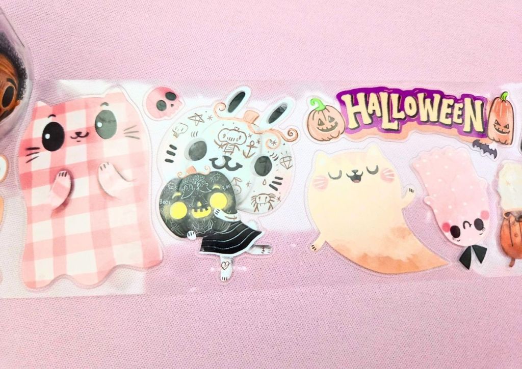 Cute pastel Halloween stickers on PET tape rolls featuring a cute pink plaid ghost, a bunny head-pumpkin character, and a cute cat ghost.