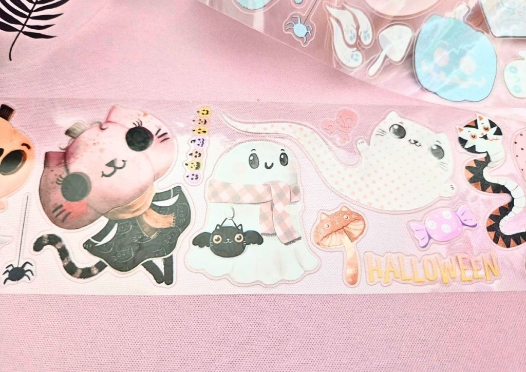 Cute pastel Halloween stickers on PET tape rolls featuring a cat ghost, a cute ghost with a scarf, and a pink pumpkin cat head on a small body wearing a black dress.