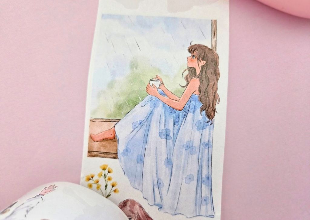 A girl wearing a long blue dress and sitting by a window, looking at the rain outside.