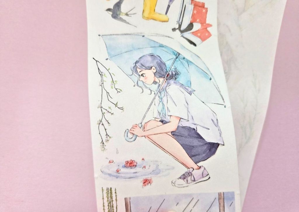 A girl crouching next to a rain puddle and holding a big blue umbrella.