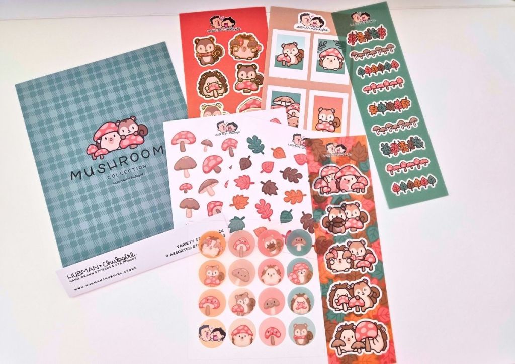 A set of colorful mushroom-themed stickers, including animals, mushrooms, and leaves, displayed with a green plaid cardstock backing labeled Mushroom Collection on a white background.