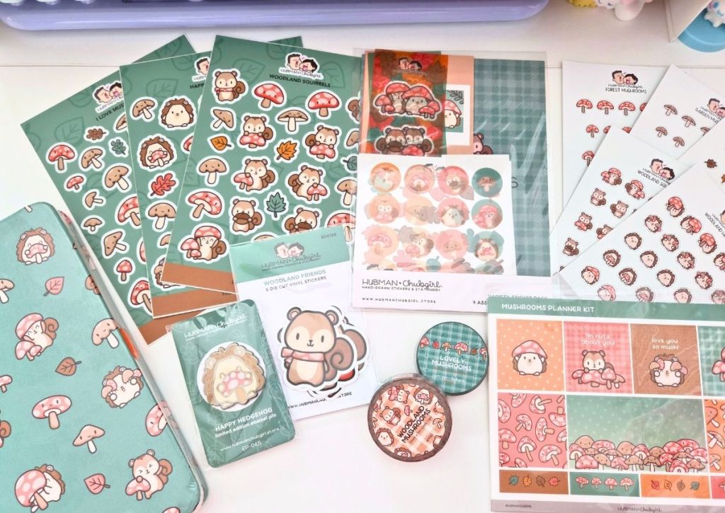 A collection of cute, woodland-themed stationery items with mushrooms, squirrels, and leaves, all in pastel colors, arranged on a white surface.