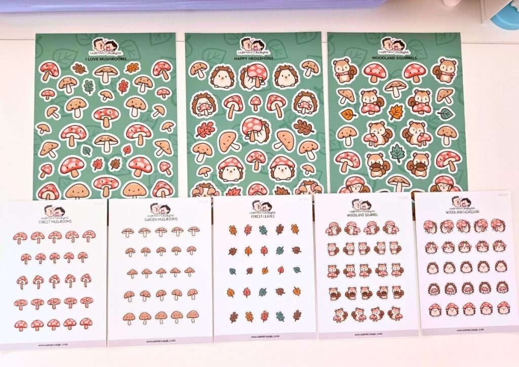 Nine sheets of stickers featuring mushrooms, hedgehogs, leaves, and squirrels in cute cartoon style. The top row has larger stickers; the bottom row has smaller versions of each design.