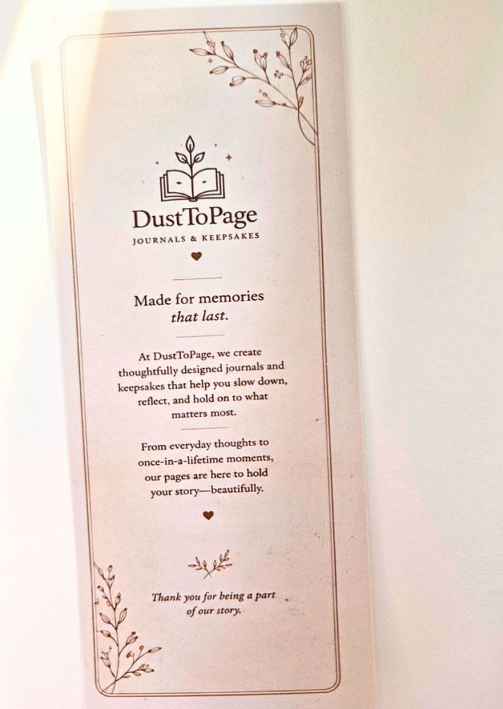 Informational card for DustToPage Journals & Keepsakes featuring a floral border, a book logo, and a message about the brands mission to preserve memories.