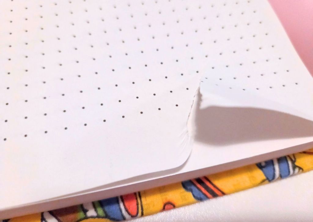 A corner of a page with a dot grid pattern being torn.