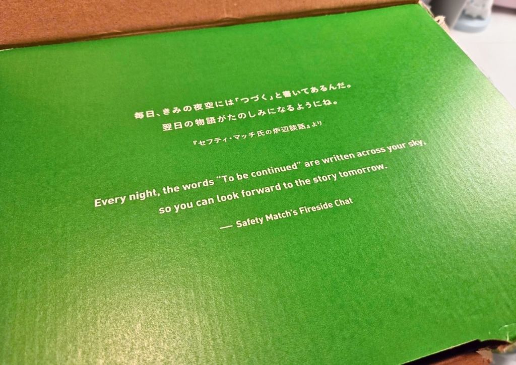 Green packaging interior printed with a quote in Japanese and English that reads, Every night, the words To be continued are written across your sky, so you can look forward to the story tomorrow.