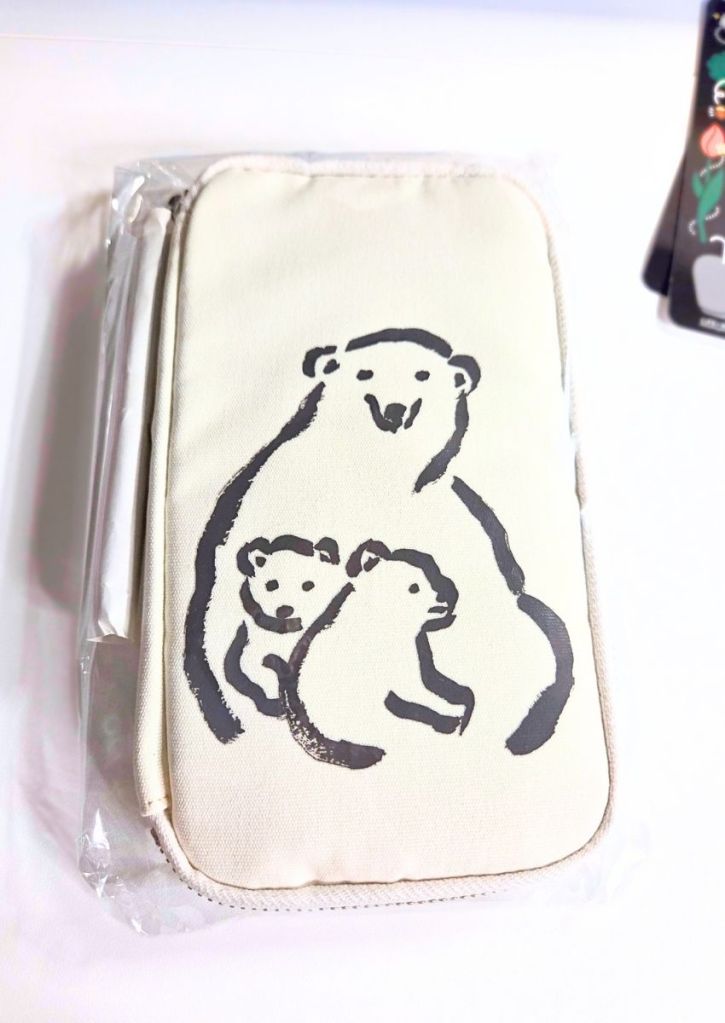 A cream-colored zippered pencil case featuring a black ink illustration of a mother polar bear with two cubs.