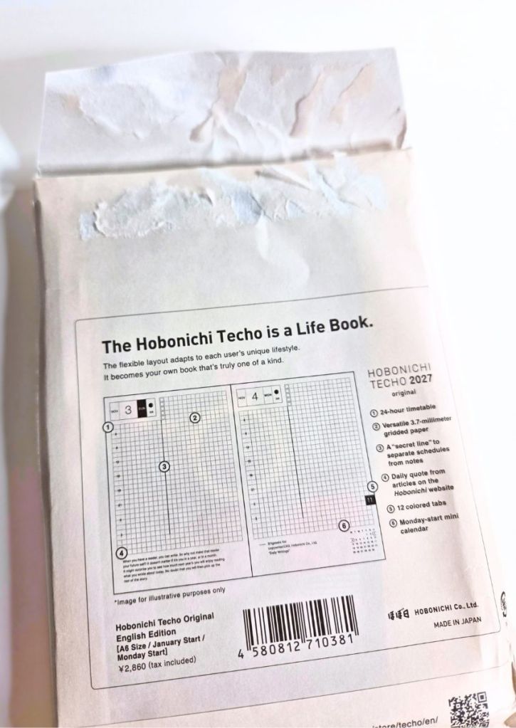 Back of a Hobonichi Techo 2027 planner package, showing product features and a diagram of the gridded page layout.